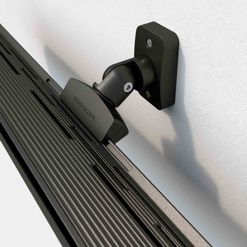 Close-up of the back attachment part of a black Heatscope Outdoor Pure+ heater mounted on a white wall, showcasing its sleek design for outdoor living.