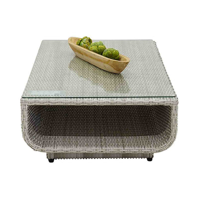 Outdoor furniture Rossland collection featuring wicker lounge chair, sofas, and a glass table with a bowl of broccoli on it.