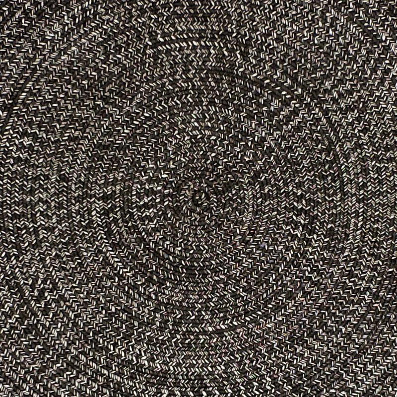 Close-up of a black round rug, highlighting the circular pattern, perfect for outdoor furniture setups.