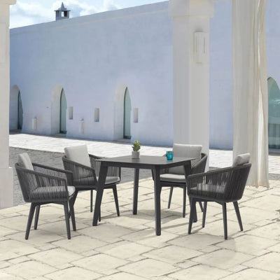 Black Truro outdoor aluminum square dining table with a ceramic glass top (90 cm), accompanied by four matching outdoor rope chairs, set in the outdoor area of a modern house, offering the perfect setup for outdoor living and alfresco furniture.