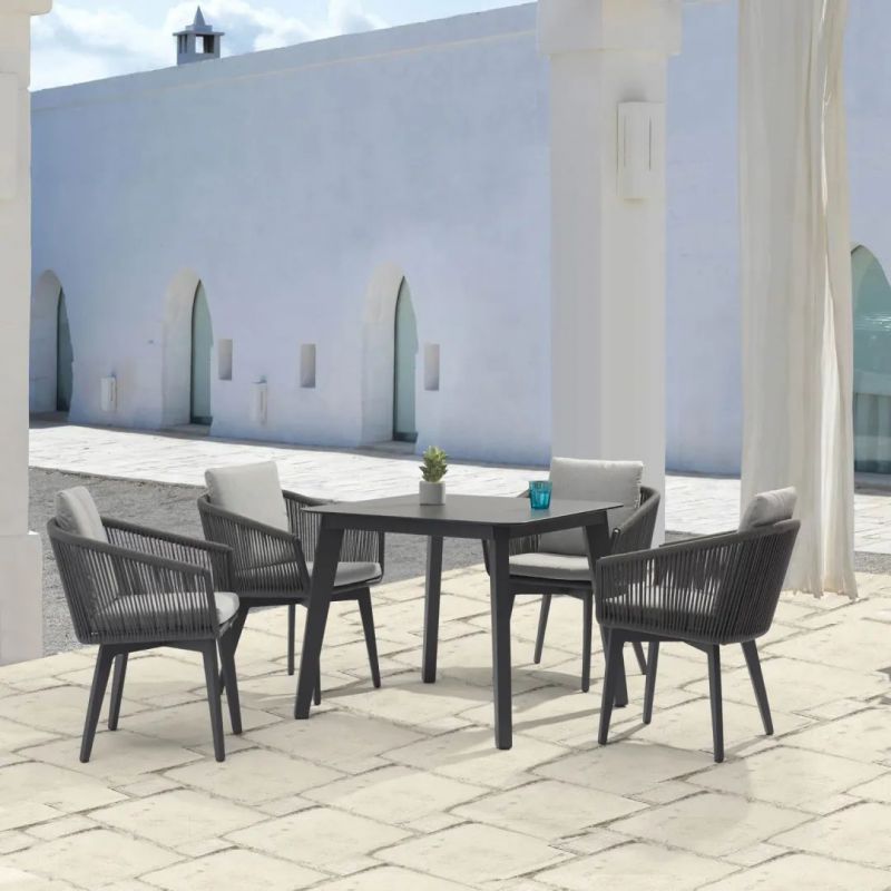 Black Truro outdoor aluminum square dining table with a ceramic glass top (90 cm), accompanied by four matching outdoor rope chairs, set in the outdoor area of a modern house, offering the perfect setup for outdoor living and alfresco furniture.