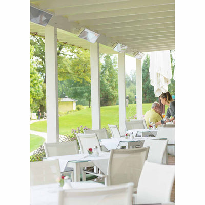 A group of Heatscope Outdoor Vision 3200W heaters delivering warmth in an outdoor eating area at a golf club, with greenery in the background, perfect for outdoor living.