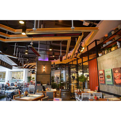 Multiple Heatscope Outdoor Vision 3200W heaters overhead in a trendy restaurant, ensuring customers stay warm while enjoying the outdoor living experience.