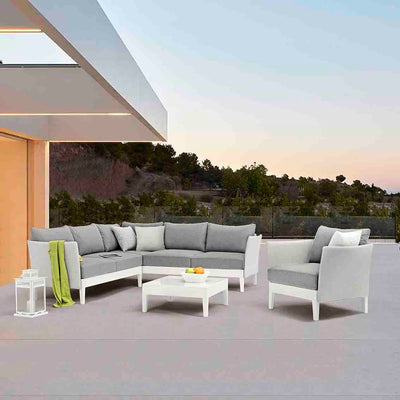 White and light grey Belfast Outdoor Aluminium Armchair, 6 Seater Outdoor Aluminium Lounge, and Square Coffee Table set on an outdoor area of a modern house, creating a stylish outdoor living space perfect for relaxation.