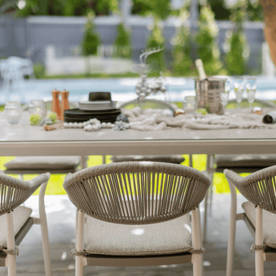 Outdoor furniture: The Windsor Dining Chair, a rope chair with white frame and light grey fabric, set outdoors.