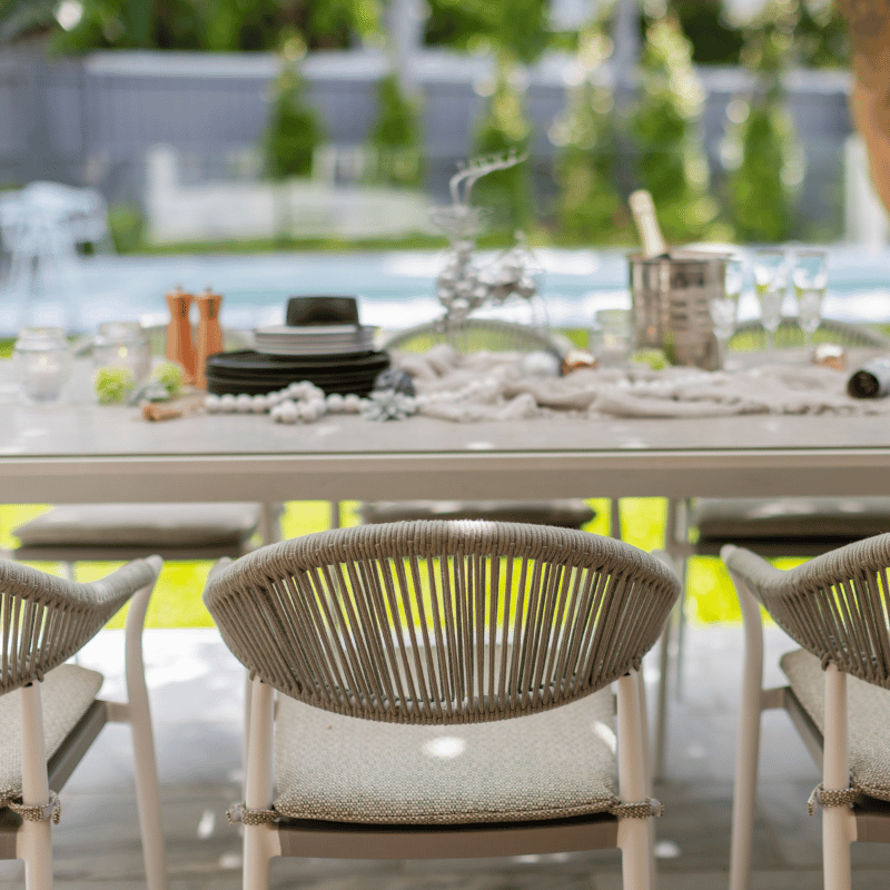 Outdoor furniture: The Windsor Dining Chair, a rope chair with white frame and light grey fabric, set outdoors.