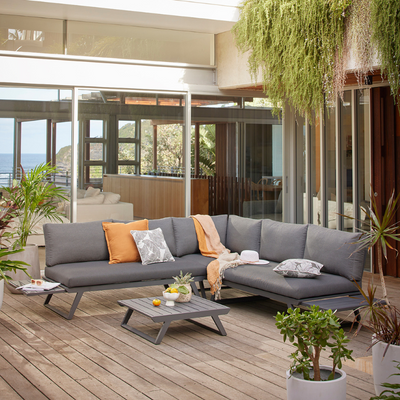 Aluminum outdoor furniture from Yarra Sofa Series on a patio, including an outdoor lounge chair, coffee table, and potted plants.
