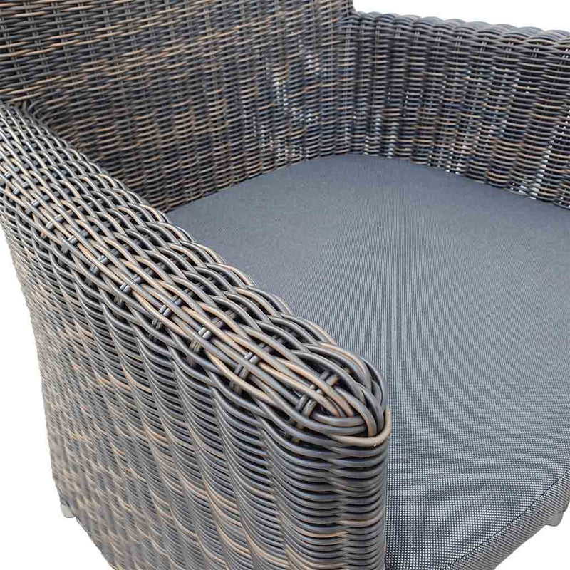 A close-up view of a wicker dining chair with charcoal frame and dark grey fabric set against a white background. Outdoor furniture, outdoor chairs, outdoor balcony furniture.