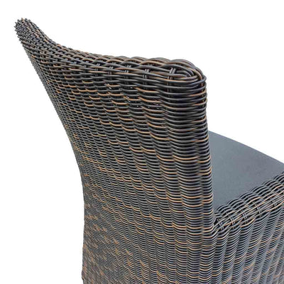 Outdoor furniture: A back view of a wicker dining chair with charcoal frame and dark grey fabric set against a white background. Outdoor chairs, outdoor balcony furniture.