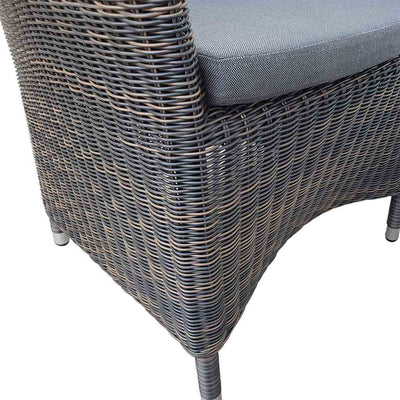 A close-up view of a wicker dining chair with charcoal frame and dark grey fabric set against a white background. Outdoor furniture, outdoor chairs, outdoor balcony furniture.