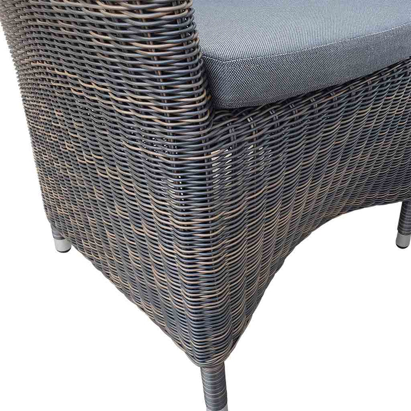 A close-up view of a wicker dining chair with charcoal frame and dark grey fabric set against a white background. Outdoor furniture, outdoor chairs, outdoor balcony furniture.