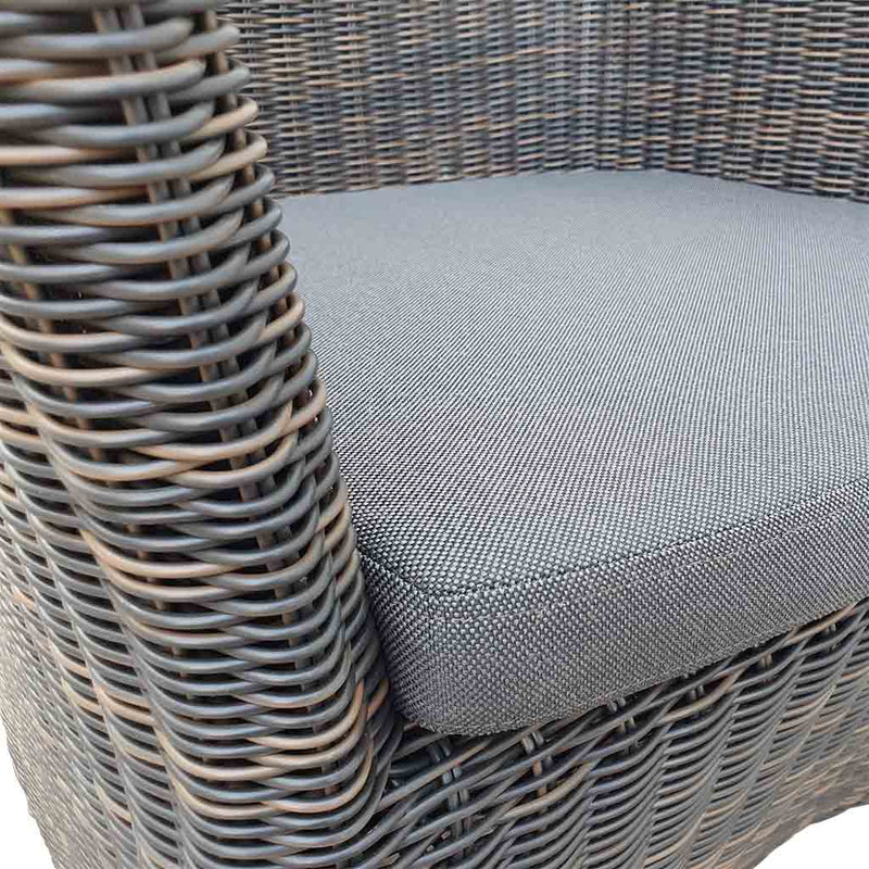 A close-up view of a wicker dining chair with charcoal frame and dark grey fabric set against a white background. Outdoor furniture, outdoor chairs, outdoor balcony furniture.