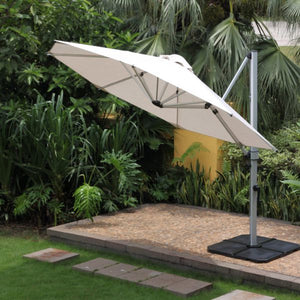 Light brown outdoor umbrella providing shade to a backyard area with lush greenery in the background, enhancing the outdoor living space.