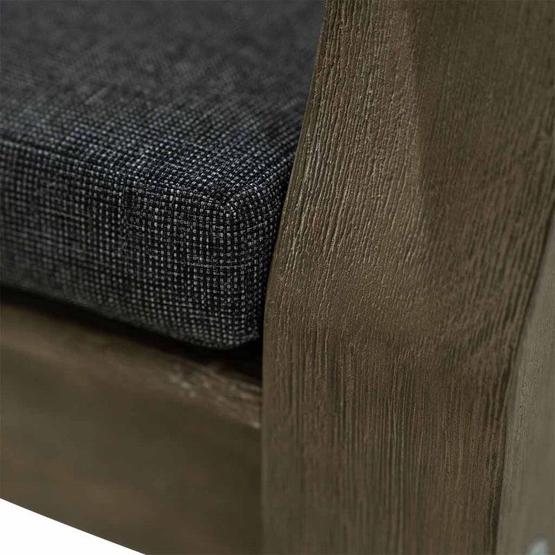 A close-up on the side of a 150cm dark brown wooden outdoor bench with a dark grey fade-resistant seat cushion. The bench is made of high-quality acacia wood, and perfect for any outdoor setting. It is displayed on a plain white background.